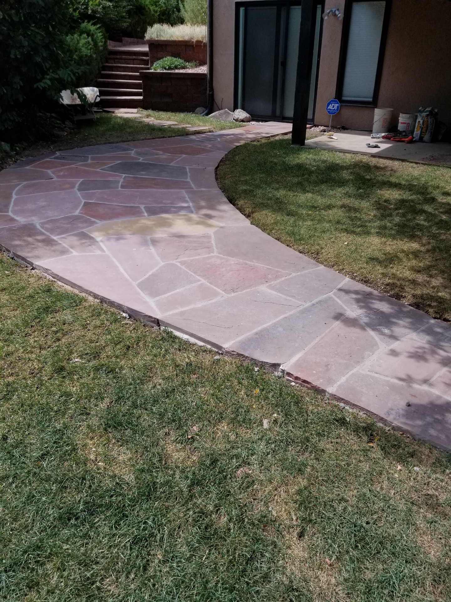 Completed flagstone walkway with lush green lawn